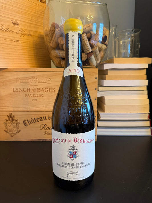 Wine bottle of Château de Beaucastel - Châteauneuf-du-Pape Blanc 2019 with cork display on a wooden board.