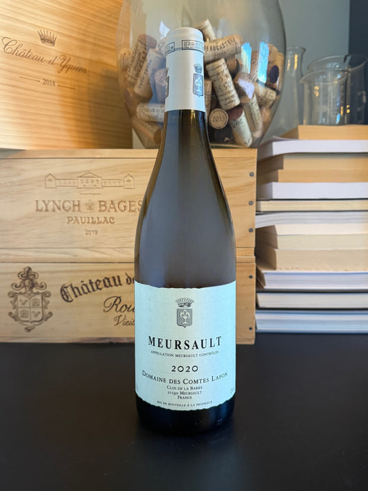 Wine bottle of Domaine des Comtes Lafon Meursault 2020 with a wooden box and books in the background.