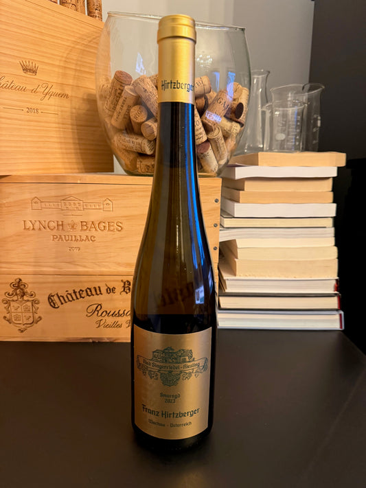 Wine bottle of Hirtzberger’s Singerriedel Riesling 2023 with books in the background.